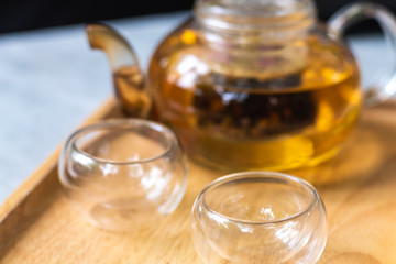 Focus cup of tea with teapot background on the table .Process brewing tea,tea ceremony,Cup of freshly brewed tea,The Time of Tea Break.