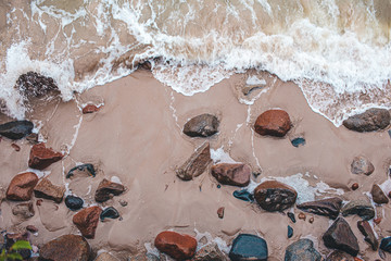 Aerial view of crashing waves on stones View from above, beautiful nature background.