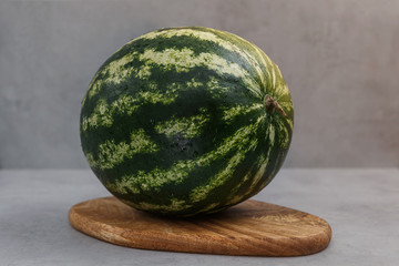 Fresh watermelon on a wooden cutting board. Berries and fruits, vegetarian and healthy eating. Front view.