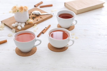 Obraz na płótnie Canvas Cups of hot tea on white wooden table