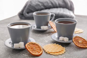 Cups of hot tea and waffles on table