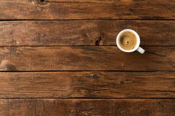 Overhead shot of hot coffee cup on wooden background with copyspace