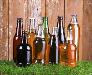 glass bottles with beer on the grass