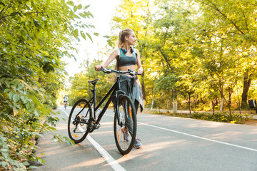 Cheerful young fitness girl carrying backpack