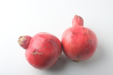 two pomegranates on light background. Image contains copy space
