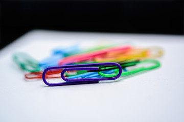Paper clips of various colors on a white folio