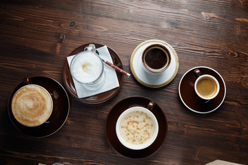 Cappuccino on a brown wooden background. Menu