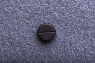 Closeup of absorbent charcoal pill, top view