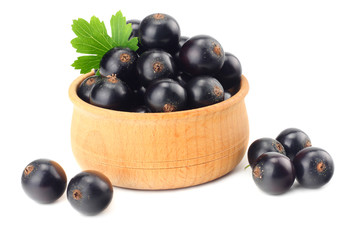black currant in wooden bowl with green leaf isolated on white background