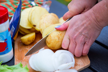  Female hands chop vegetables for frying. Horizontal.