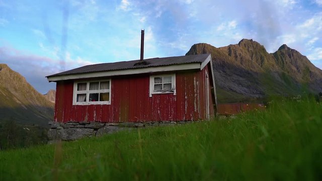 A red small house in the mountains. Camera movement towards the house. From &Oslash;rsta, Norway.