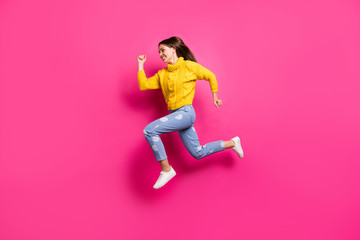 Fototapeta na wymiar Full body profile side photo of cheerful lady jumping running wearing yellow pullover dotted denim jeans isolated over fuchsia background