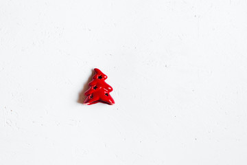 One red Christmas toy on a white textured background.