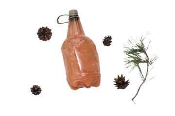 Brown plastic bottle with a sprig of pine and a fir cone on a white background.