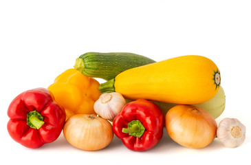 Vegetable set of bright ripe appetizing fruit peppers onion zucchini and garlic pink tomato and hot chili peppers on a white background