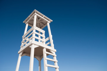 A tall white lifeguard tower with ladder