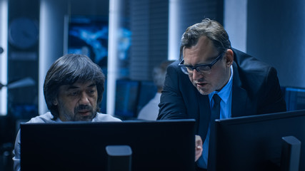 Government Chief of Cyber Security Consults Operations Officer who Works on Computer. Specialists...