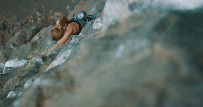 Strong fit rock climber making her way up an outdoor sport climbing route