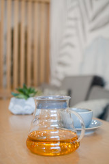 herbal tea in a transparent glass teapot in the interior of a modern Scandinavian cafe