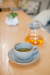 herbal tea in a transparent glass teapot in the interior of a modern Scandinavian cafe