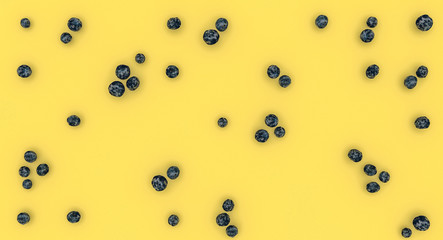 blueberries on a yellow background. Flat lay style.