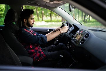 Portrait of indian handsome man driving a car