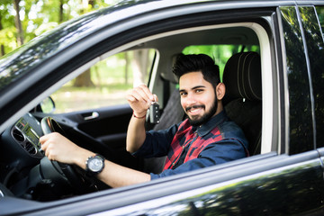 Happy indian man showing the key of his new car