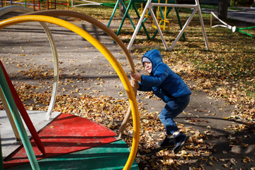 Happy boy playing in the autumn park, funny 4 years old toddler, seasonal walking outdoor, bright color of the weather, sunny day
