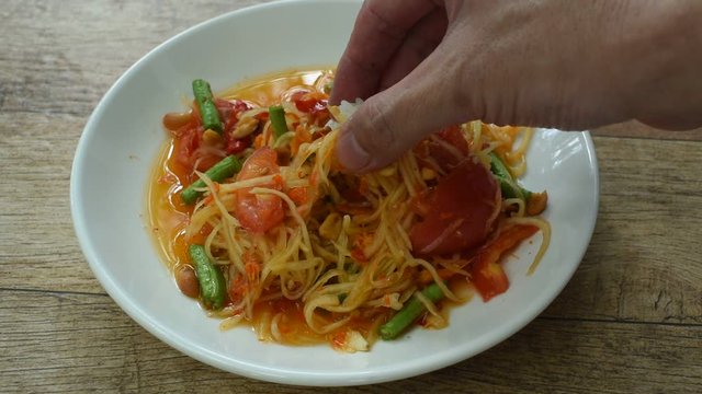 Somtum Thai spicy green papaya salad eat with sticky rice by hand