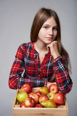 Teen girl with apples and pears in a box