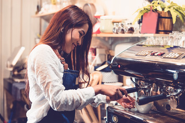 Fototapeta na wymiar Professional female barista hand making cup of coffee with coffee maker machine in restaurant pub or coffee shop. People and lifestyles. Business food and drink concept. Happy shop owner entrepreneur