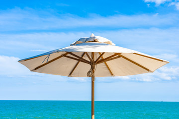 Obraz na płótnie Canvas Beautiful umbrella and chair around beach sea ocean with blue sky for travel