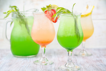 A variety of soft drinks. Assortment of soft drinks. Tarragon lemonade, Strawberry lemonade, Pear lemonade. Lemonade on a light background.