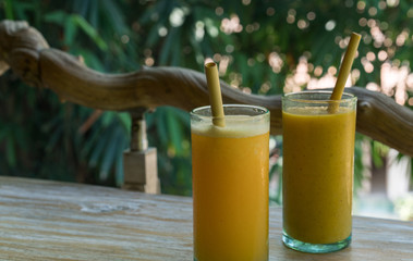 Zero waste concept with reuse bomboo straw, tropical delicious juice, Thai Bali seasonal, cool ice beverage for refreshing in summer on green nature bokeh background