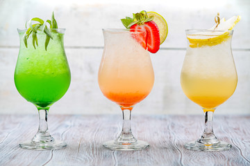 A variety of soft drinks. Assortment of soft drinks. Tarragon lemonade, Strawberry lemonade, Pear lemonade. Lemonade on a light background.