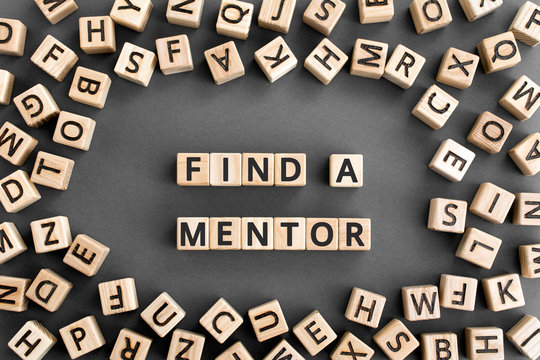Find a mentor - phrase from wooden blocks with letters, Online mentorship a voluntary counselor or teacher concept, random letters around, grey background