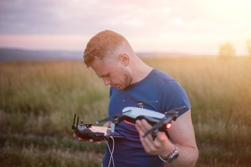 The young man manipulates the drone using the control panel. New technologies and trends in photo and video recording. record footage in the air.