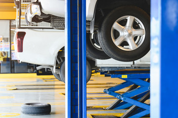 Pickup car raised on car lift in auto service garage center for tire change. Automotive car repairing and maintenance concept. © Shutter2U