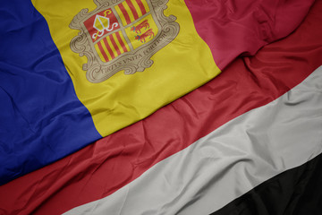 waving colorful flag of yemen and national flag of andorra.