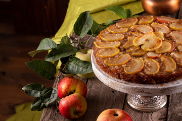 French sweet pie tart tatin apple cake upside down and fresh apples  over on old rustic wooden...