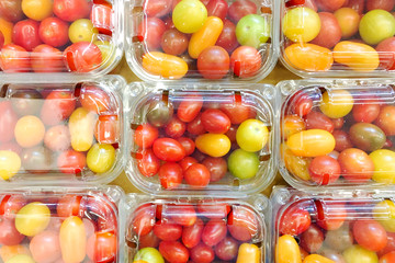 Mix of cherry tomatoes in a package on a display case.