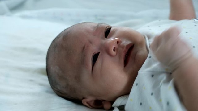Close up head newborn baby crying sad. Thai nationality boy.