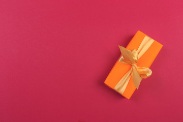 Gift box with ribbon and bow on color background and space for text. Top view - Image