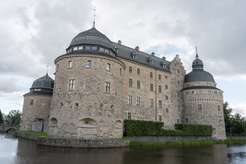 Fototapeta premium Orebro castle with clouds. Castle view from pond side. Travel photo, background or illustration.