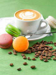 Cup of aromatic coffee cappuccino with colored cookies