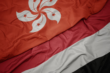 waving colorful flag of yemen and national flag of hong kong.