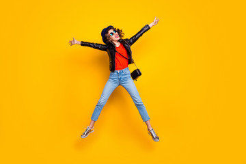 Fototapeta na wymiar Full length photo of cheerful lovely funny youth girl jump enjoy weekends wear denim jeans black modern jacket isolated over yellow color background