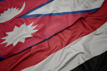waving colorful flag of yemen and national flag of nepal.