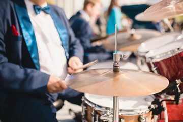 Close-up of a drum cymbal drummer knocking on it with chopsticks - selective focus