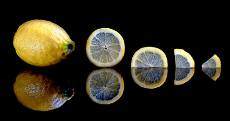 shot of sliced and whole lemons isolated on black background